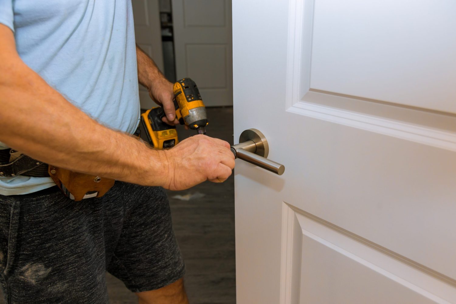 Hands repairing a door lock with a door knobs